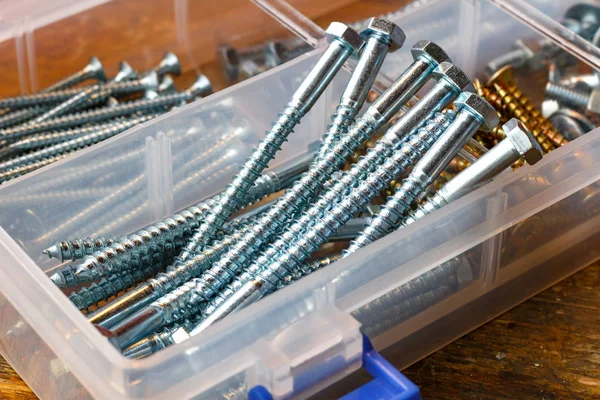 Large self-tapping screws for wood in storage box on a workbench — Stock Photo, Image