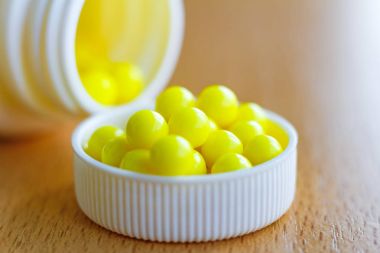 Beyaz plastik bir şişe kapağı üzerinde tablo portre sarı vitamin