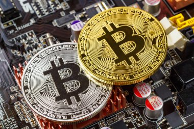 Bilgisayar anakart arka plan portre üzerinde gümüş ve altın bitcoins. Cryptocurrency sanal para