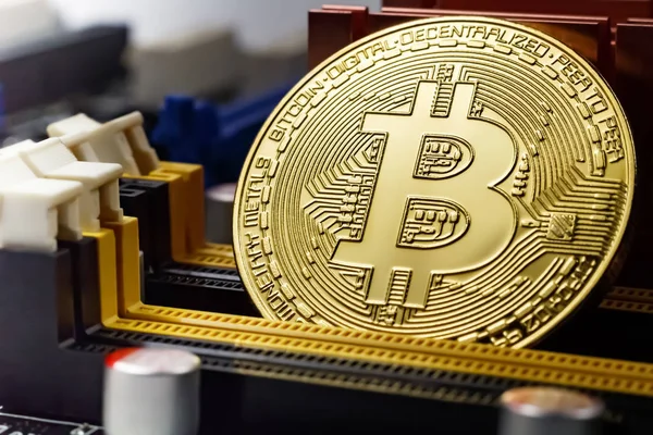Golden bitcoin на заднем плане материнской платы компьютера. Виртуальные деньги в криптовалюте — стоковое фото