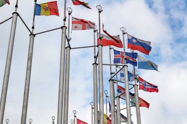 Bulutlu gökyüzü arka plan üzerinde farklı ülkelerin bayrakları