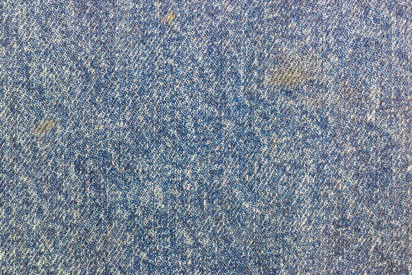 Abstract texture of old blue cotton fabric with dirty spots. Natural fabric background