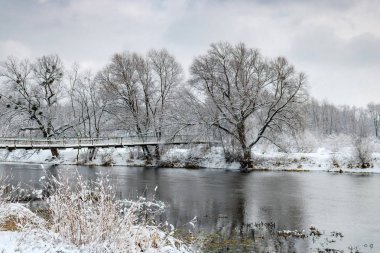 Bir bulutlu kış günü kar yağışı sonra nehir banka. Kış manzarası