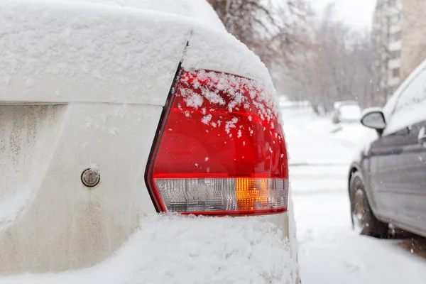 Snötäckta bil svans ljus närbild. Bil på vintern — Stockfoto