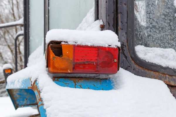 Tractor viejo luz trasera primer plano cubierto de nieve en invierno — Foto de Stock