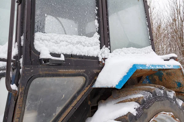 Fragment de la vieille cabine du tracteur recouvert de neige gros plan — Photo