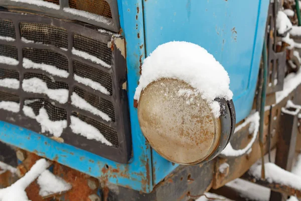 Huvudsakliga strålkastare av gamla traktor närbild täckt med snö på vintern — Stockfoto