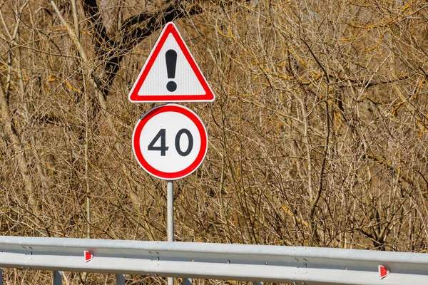 Verkeersborden achtergrond van struiken gevaar vooruit en maximumsnelheid 40 — Stockfoto