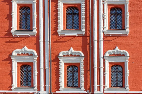 Finestre con griglie metalliche decorative sulla facciata di mattoni rossi di primo piano casa antica — Foto Stock