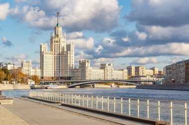 Moskova, Rusya - 08 Ekim 2019: Güneşli sonbahar gününde Moskva Nehri 'ndeki yolcu gemilerine karşı Kotelnicheskaya Embankment' taki ünlü Stalin gökdeleninin görüntüsü