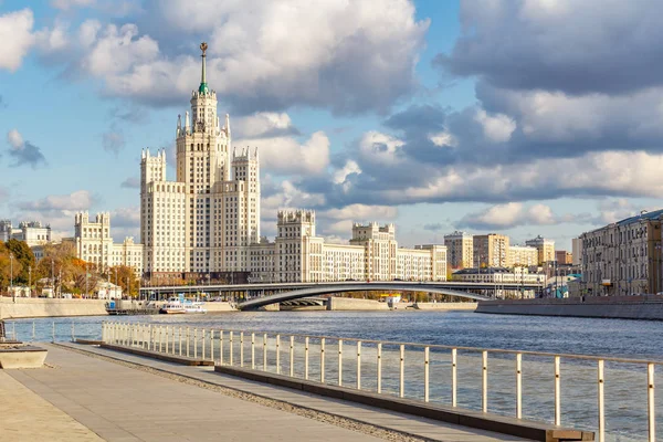 Moskva, Ryssland - 08 oktober 2019: Utsikt över berömda stalin skyskrapa på Kotelnicheskaya Bankment mot piren av kryssningsfartyg på Moskva River i solig höstdag — Stockfoto