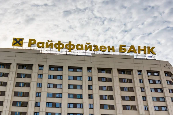 Moscou, Rússia - 03 de outubro de 2019: Sinalização do Banco Raiffeisen no telhado do edifício alto contra o céu azul com nuvens na manhã ensolarada. Banco de Raiffeisen sinal — Fotografia de Stock