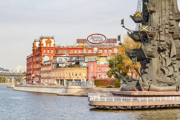 Moskova, Rusya - 3 Ekim 2019: Moskova şekerleme fabrikası Red October 'a karşı Moskva Nehri' nde güneşli bir sonbahar gününde Büyük Peter anıtı