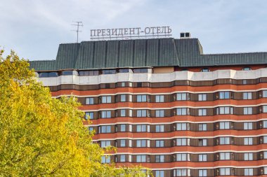 Moskova, Rusya - 3 Ekim 2019: Moskova 'daki Başkan-Otel cephesi güneşli bir günde renkli sonbahar yapraklı ağaca karşı