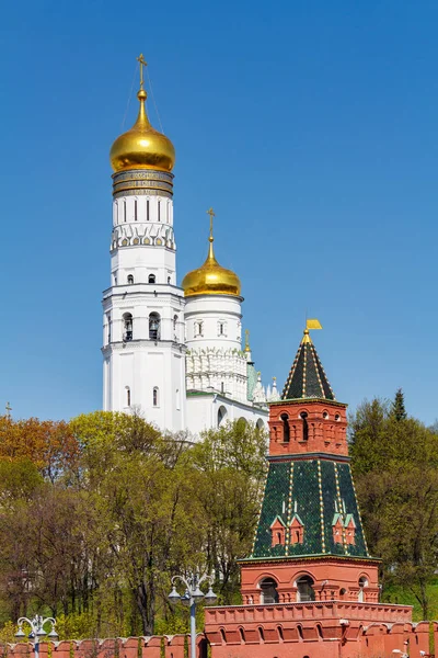 Moscú, Rusia - 01 de mayo de 2019: Iván el Gran Campanario en la colina verde contra la torre y la pared del Kremlin de Moscú en la soleada mañana de primavera — Foto de Stock