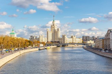 Moskova, Rusya - 08 Ekim 2019: Güneşli sonbahar gününde Moskova şehir merkezindeki Kotelnicheskaya Embankment 'taki ünlü Stalin gökdelenine karşı Moskva Nehri manzarası. Moskova sonbaharda