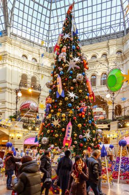 Moskova, Rusya - 21 Kasım 2019: Kızıl Meydan 'daki Sakız' da Yeni Yıl. Moskova 'daki Sakız Devlet Mağazası' nın merkezindeki süslü Noel ağacının yakınındaki insanlar.