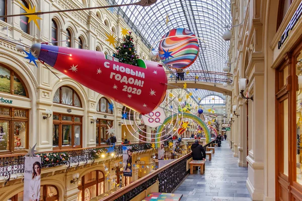 Moscou, Rússia - 21 de novembro de 2019: Nave espacial vermelha brilhante com árvore de natal e presentes no tabuleiro acima do beco da GUM State Department Store em Moscou. Interior de Natal de GUM em Praça Vermelha — Fotografia de Stock