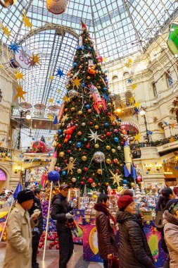 Moskova, Rusya - 21 Kasım 2019: Kızıl Meydan 'daki Sakız' da Yeni Yıl. Moskova 'daki Sakız Devlet Mağazası' nın merkezindeki Noel ağacının yakınındaki turistler