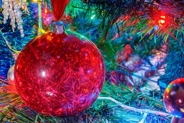 Bola de Navidad roja de plástico transparente con oropel brillante en el interior en la rama de abeto decorativo de primer plano Fotos De Stock Sin Royalties Gratis