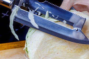 Paslanmaz çelik bıçak, taze beyaz lahanayı öğütüyor. Yakın çekim görünümü