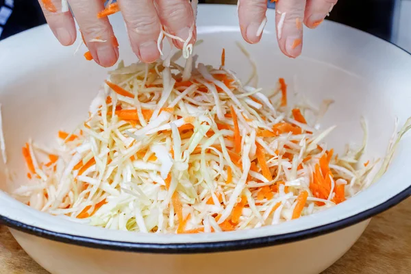Woman hands above metal bowl after mixing fresh shredded white cabbage with juicy grated carrot — Stock Photo, Image