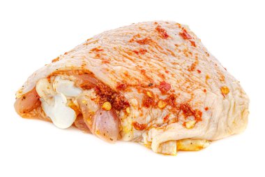 Baharatla marine edilmiş beyaz arka planda izole edilmiş parlak yüzeyde yansıması olan bir parça tavuk budu.