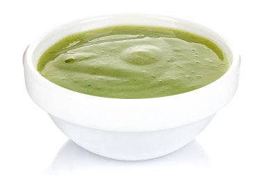 Beyaz arka planda izole edilmiş küçük beyaz bir seramik kasede limonlu yeşil biber sosu.