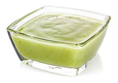 Yeşil biber sosu, beyaz arka planda izole edilmiş küçük şeffaf cam bir kasede limon.