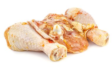 Baharatlı tavuk budu ve beyaz arka planda izole edilmiş tavuk budu ile marine edilmiş, parlak yüzeyde yansıması var.