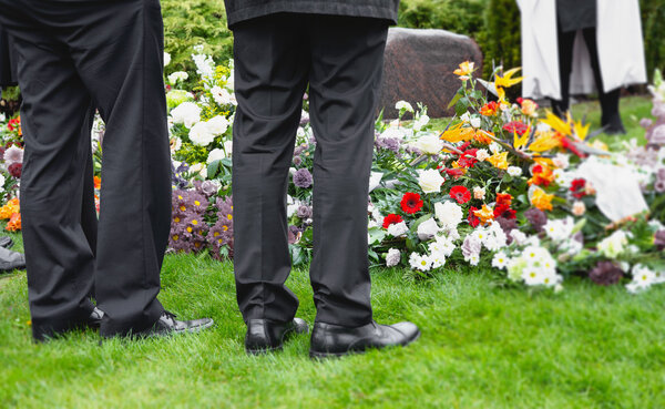 Two men watcjing funeral flowers