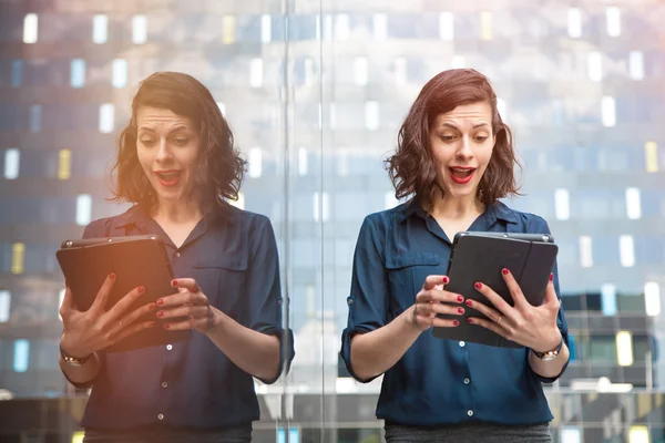 Excited young successful businesswoman getting good results on a tablet — Stock Photo, Image
