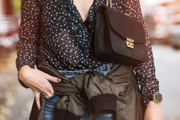 Dettagli moda abbigliamento autunno. elegante giovane donna che indossa jeans e una camicia trasparente. fashion blogger posa in abito autunnale con accessori . — Foto Stock