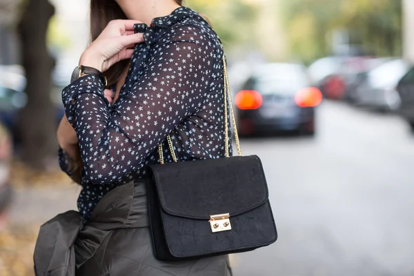 Primer plano de los detalles de moda de otoño. mujer de negocios joven y atractiva sosteniendo el bolso y usando una ver a través de camisa y reloj de oro y joyas, colores cálidos . — Foto de Stock