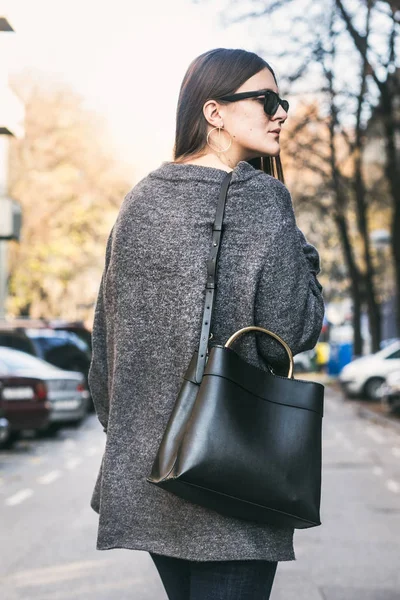 Στολή τέλεια πτώση. μοντέρνα κοπέλα φορώντας ένα γκρι oversized πουλόβερ και ένα μοντέρνο τσάντα μαύρη — Φωτογραφία Αρχείου