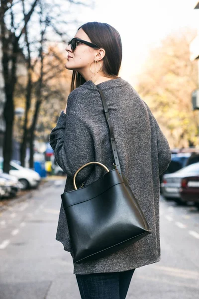 Идеальный осенний наряд. модная молодая женщина в сером свитере и модной черной сумочке — стоковое фото
