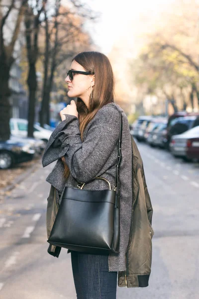 Perfekt höst outfit. fashionabla ung kvinna som bär en grå oversized tröja, oliv bombplan jacka och en trendig svart handväska — Stockfoto