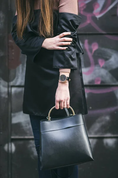 Perfekt efterår outfit. stilfuld kvinde med en elegant sort håndtaske med et gyldent håndtag . - Stock-foto
