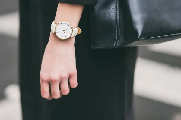 Giovane donna d'affari che tiene la sua borsa nera elegante. indossando orologio d'oro e bianco. accessori abbigliamento autunno ideale . — Foto Stock