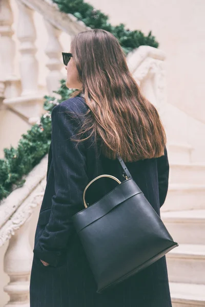 Detalles de ropa de blogger de moda. mujer de moda con un abrigo de gran tamaño azul no y un bolso de moda negro. detalles de un atuendo de moda de otoño perfecto . —  Fotos de Stock