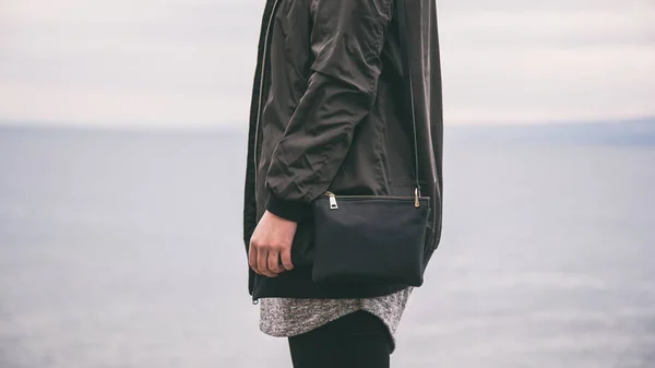 Detalles de la moda del traje de otoño, mujer joven y elegante con una chaqueta de bombardero de moda y sosteniendo un bolso negro de moda — Foto de Stock