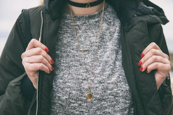 Fall fashion outfit detail. woman in an autumn fashion outfit, stylish bomber jacket and grey sweater. wearing trendy jewelry - a black choker necklace. warm instagram grade. — Stock Photo, Image