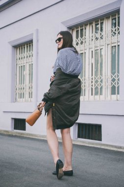 mükemmel bahar moda kıyafet. güneş gözlüğü, Pötikareli onay topaç, siyah etek, büyük boy bombardıman ceket, loafer'lar ve kahverengi bir çanta giyen şık genç kadın. Blogger sokakta poz moda.