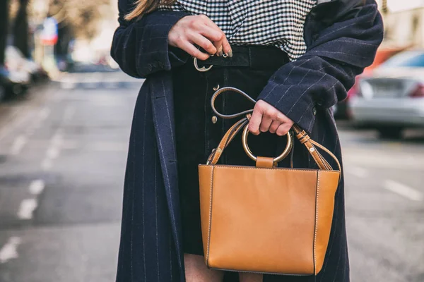 Cerrar los detalles de moda, mujer de negocios joven sosteniendo su bolso elegante marrón. vistiendo reloj negro y dorado. accesorios ideales del equipo de primavera . — Foto de Stock