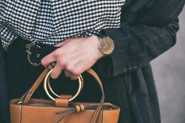 Détails de mode de près, jeune femme d'affaires tenant son sac brun élégant. portant une montre noire et dorée. accessoires de tenue de printemps idéal . — Photo