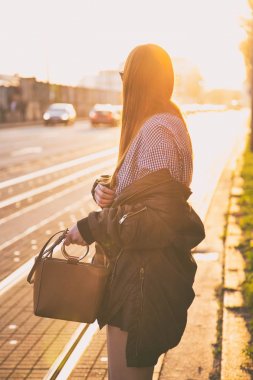 mükemmel bahar moda kıyafet. Pötikareli onay topaç, siyah etek, büyük boy bombardıman ceket, loafer'lar ve kahverengi bir çanta giyen moda kadın. Blogger sokakta günbatımında poz moda.