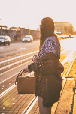 mükemmel bahar moda kıyafet. Pötikareli onay topaç, siyah etek, büyük boy bombardıman ceket, loafer'lar ve kahverengi bir çanta giyen moda kadın. Blogger sokakta günbatımında poz moda.