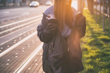 mükemmel bahar moda kıyafet. Pötikareli onay topaç, siyah etek, büyük boy bombardıman ceket, loafer'lar ve kahverengi bir çanta giyen moda kadın. Blogger sokakta günbatımında poz moda.