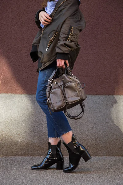 Perfekt våren mode outfit. Europeiska mode bloggare bär en trendig crossover randig blus med en främre Knut, bombplan jacka, jeans, kängor och hålla en snygg handväska. — Stockfoto