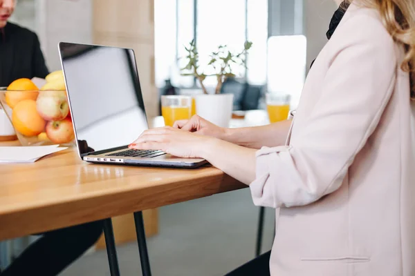 Primer plano de la mujer de negocios trabajando y escribiendo en el ordenador portátil durante la reunión en la oficina moderna . — Foto de Stock